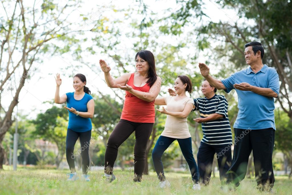 Gruppo di allievi Taiji che esegue una forma in palestra